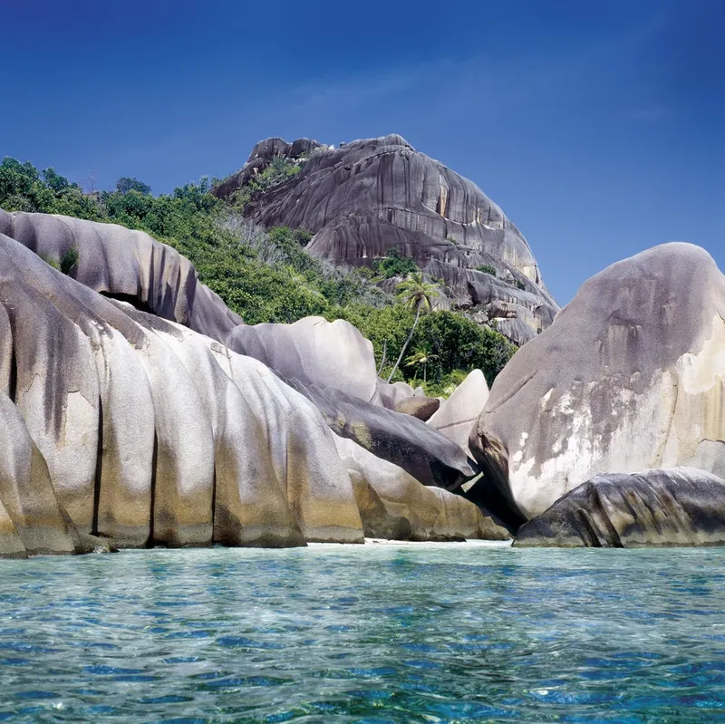 Markante Granitfelsen am türkisfarbenen Wasser der Insel La Digue auf den Seychellen.