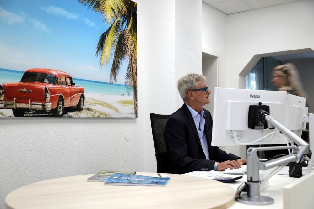 Reiseberater am Arbeitsplatz mit Kuba-Wandbild